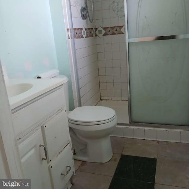 bathroom featuring vanity, toilet, tile patterned floors, and walk in shower