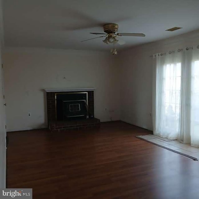 unfurnished living room with wood-type flooring and ceiling fan