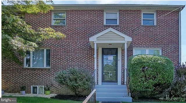 view of exterior entry featuring brick siding