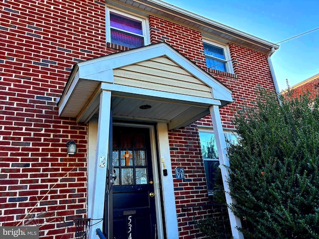 doorway to property with brick siding