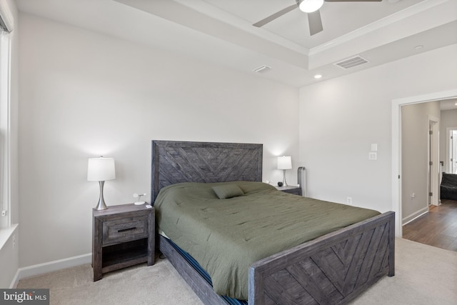 carpeted bedroom featuring a tray ceiling and ceiling fan