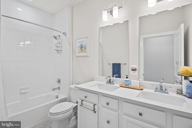 full bathroom featuring tiled shower / bath, vanity, and toilet