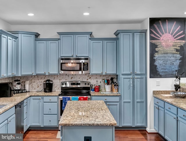 kitchen with a center island, appliances with stainless steel finishes, and blue cabinets