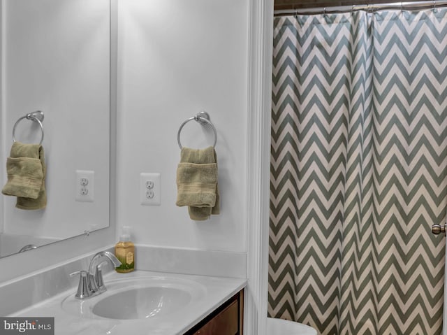 bathroom featuring vanity, toilet, and curtained shower