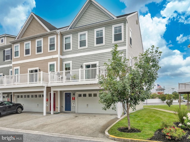 townhome / multi-family property with a garage, a balcony, and a front yard