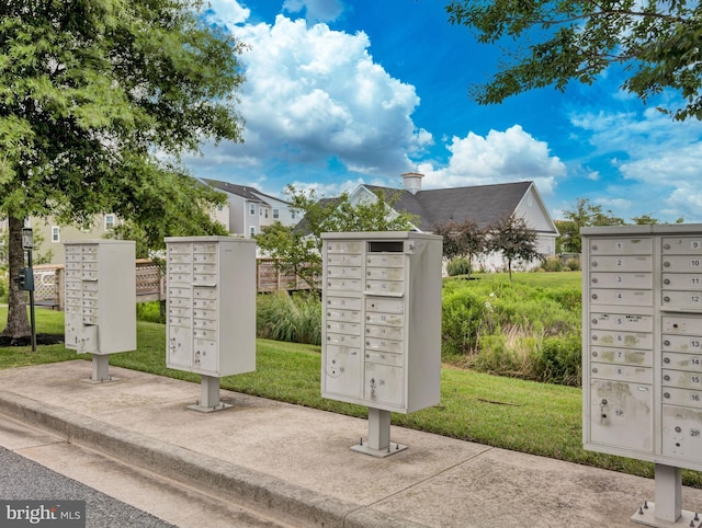 view of property's community featuring mail boxes and a lawn