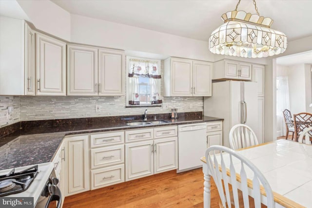 kitchen featuring pendant lighting, sink, backsplash, white appliances, and light hardwood / wood-style flooring