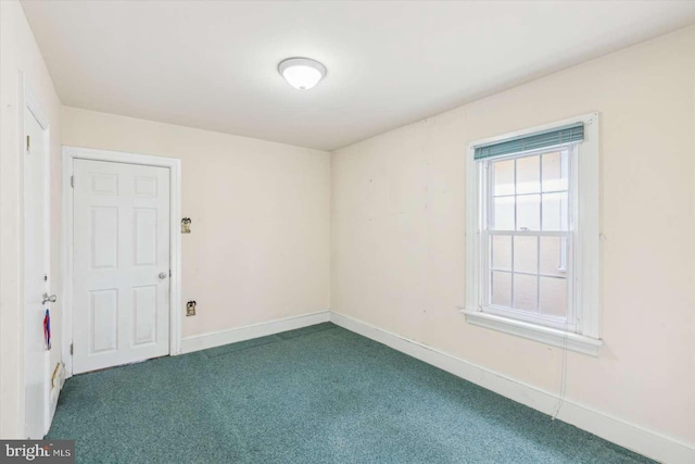 unfurnished room featuring dark colored carpet