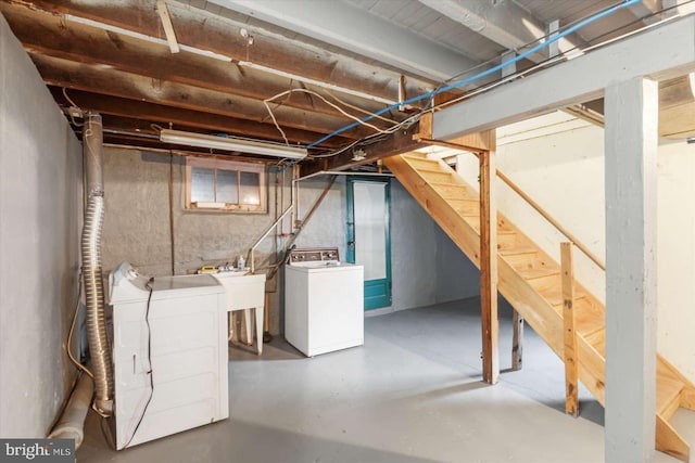 basement featuring washing machine and clothes dryer and sink