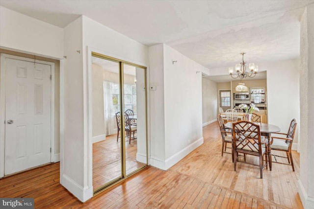 dining area featuring light hardwood / wood-style floors and a notable chandelier