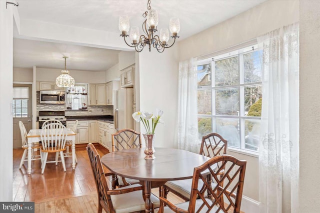 dining space with a chandelier and light hardwood / wood-style floors