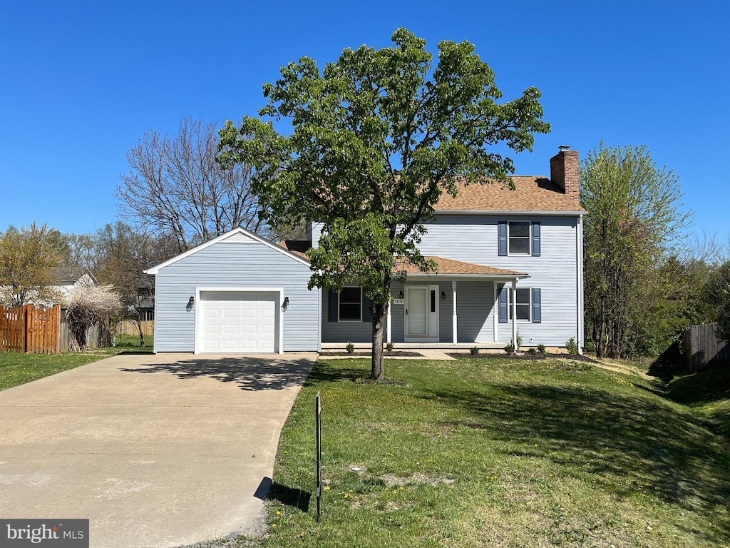 view of front of house with a garage, a front yard, and covered porch