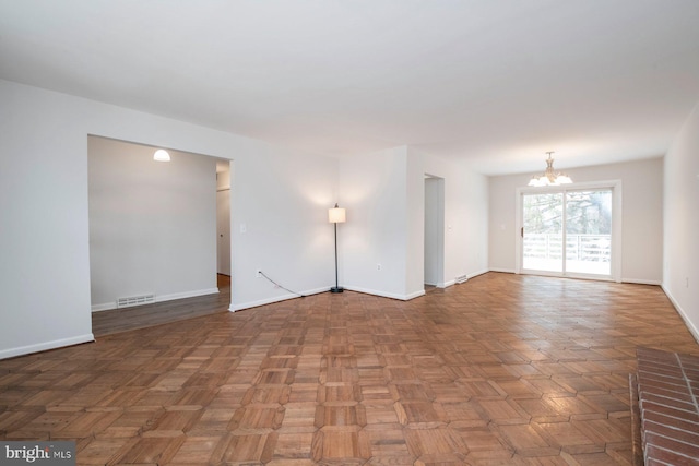 unfurnished room featuring parquet floors and a notable chandelier