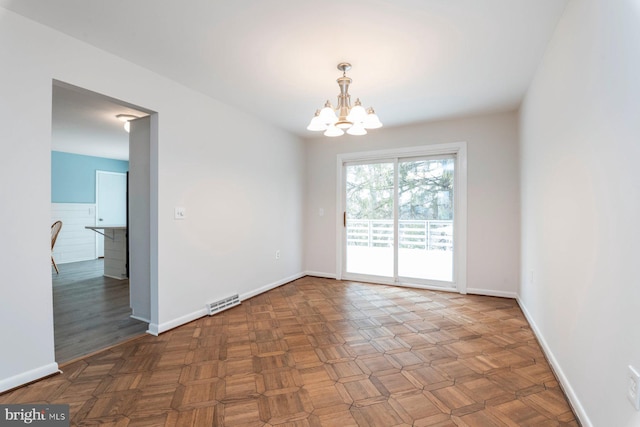 unfurnished room featuring dark parquet floors and a notable chandelier