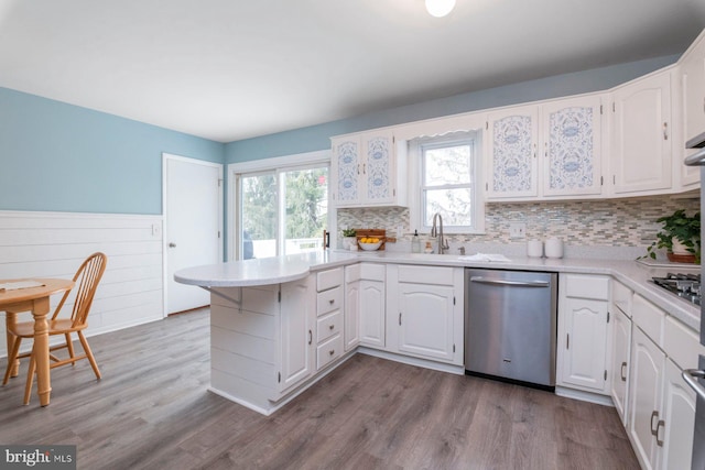 kitchen with white cabinetry, wood-type flooring, kitchen peninsula, and appliances with stainless steel finishes