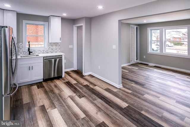 5006 Edgewood Rd, College Park, MD 20740 - kitchen featuring white cabinetry, sink, decorative backsplash, stainless steel appliances, and a healthy amount of sunlight