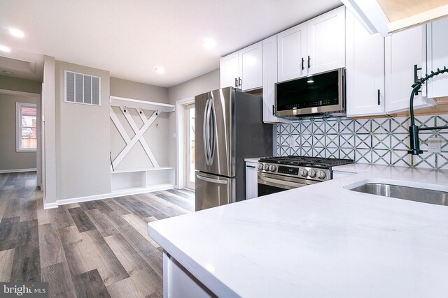 5006 Edgewood Rd, College Park, MD 20740 - kitchen with sink, white cabinetry, stainless steel appliances, light stone counters, and tasteful backsplash