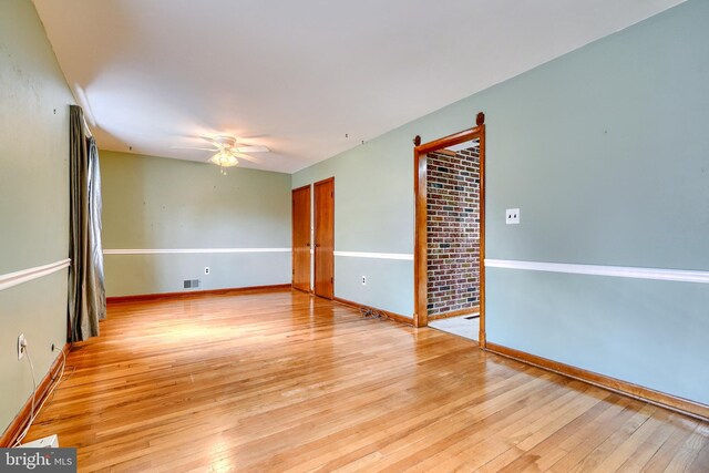 spare room with ceiling fan and light wood-type flooring