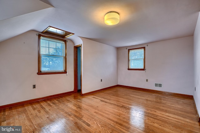 additional living space with lofted ceiling and light hardwood / wood-style flooring