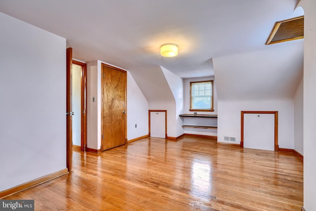 additional living space with lofted ceiling and light hardwood / wood-style flooring