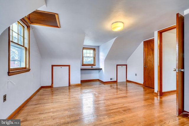 bonus room featuring vaulted ceiling and light hardwood / wood-style floors