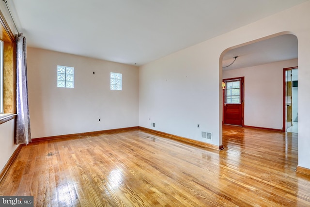 empty room with light hardwood / wood-style floors and a wealth of natural light