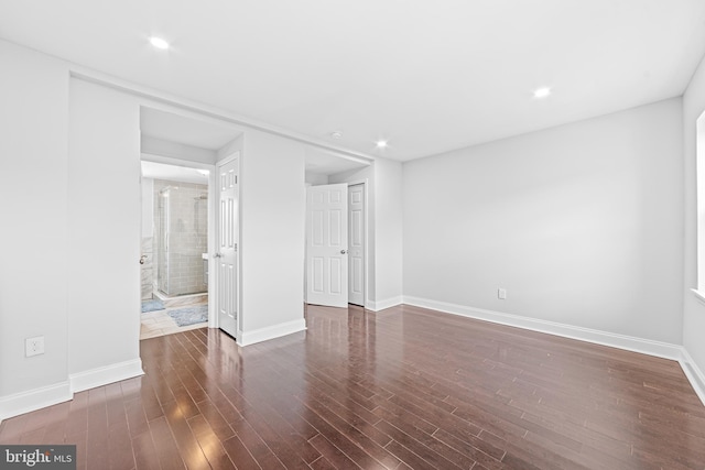 unfurnished room with dark wood-type flooring