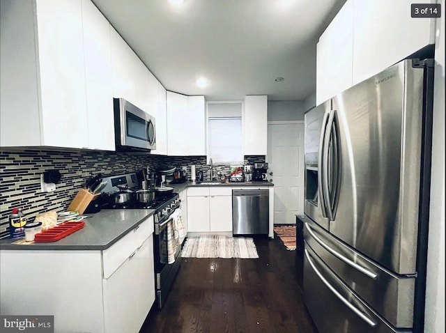 kitchen with dark hardwood / wood-style floors, sink, white cabinets, backsplash, and stainless steel appliances