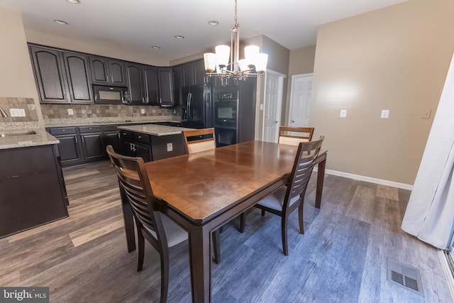 dining room featuring dark hardwood / wood-style flooring, sink, and an inviting chandelier