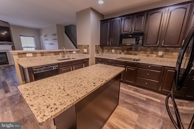 kitchen featuring dark brown cabinetry, sink, and black appliances