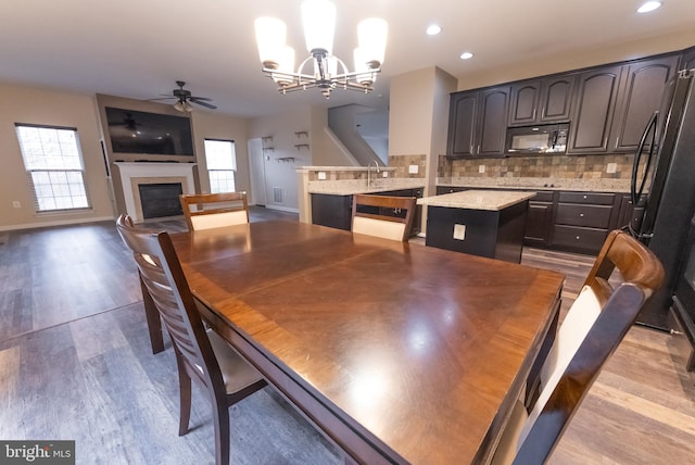 dining area featuring sink, ceiling fan with notable chandelier, a wealth of natural light, and light hardwood / wood-style floors