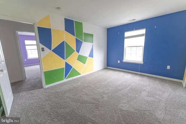 spare room featuring plenty of natural light and carpet