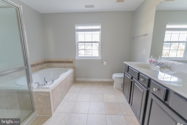 bathroom featuring tile patterned floors, toilet, vanity, and tiled tub