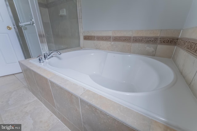 bathroom with a relaxing tiled tub