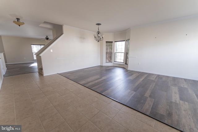 interior space featuring light hardwood / wood-style floors, ceiling fan with notable chandelier, and a wealth of natural light