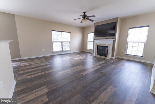 unfurnished living room featuring dark hardwood / wood-style flooring, a wealth of natural light, and ceiling fan