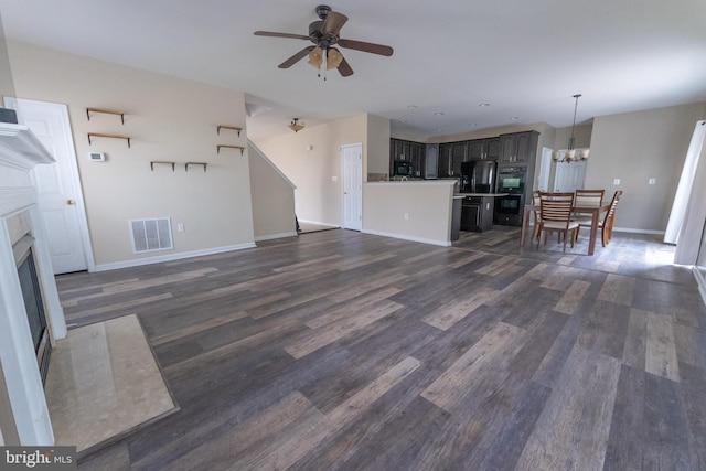 unfurnished living room featuring dark hardwood / wood-style floors and ceiling fan with notable chandelier