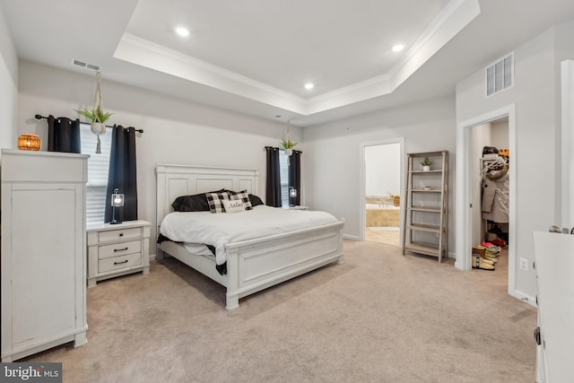 bedroom featuring crown molding, light colored carpet, a raised ceiling, and ensuite bathroom