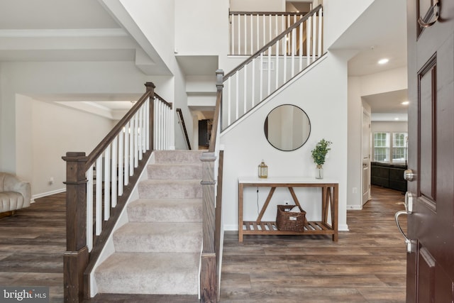 staircase featuring hardwood / wood-style flooring and a high ceiling