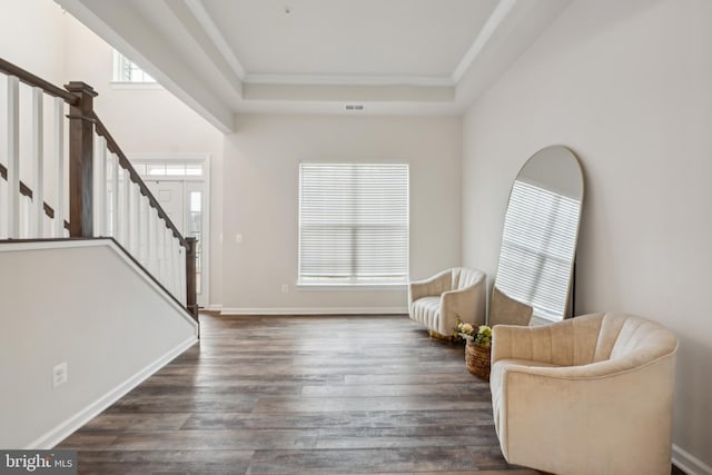 sitting room with crown molding, dark hardwood / wood-style flooring, and a raised ceiling