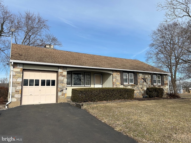 ranch-style home with a garage and a front lawn