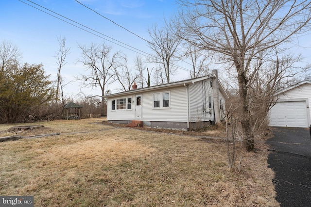 manufactured / mobile home with a garage, a gazebo, an outdoor structure, and a front lawn