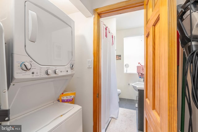 laundry area featuring stacked washer / drying machine