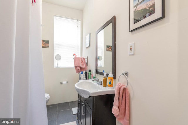 bathroom with tile patterned flooring, vanity, and toilet