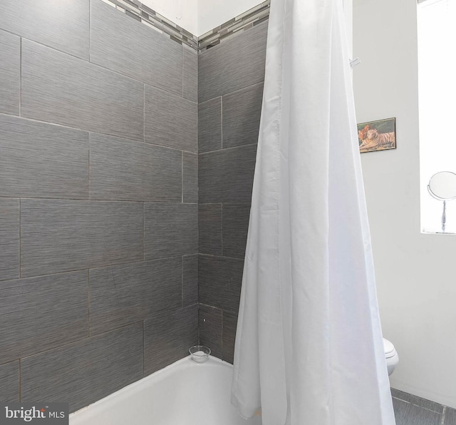 bathroom with shower / tub combo with curtain and toilet