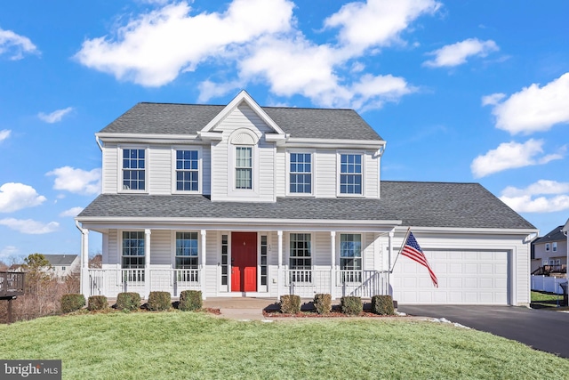 view of front facade featuring covered porch, a front yard, and a garage