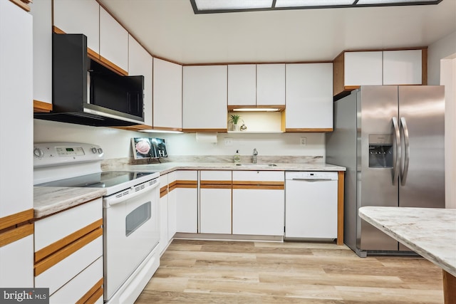 kitchen featuring light wood finished floors, open shelves, white cabinets, a sink, and white appliances