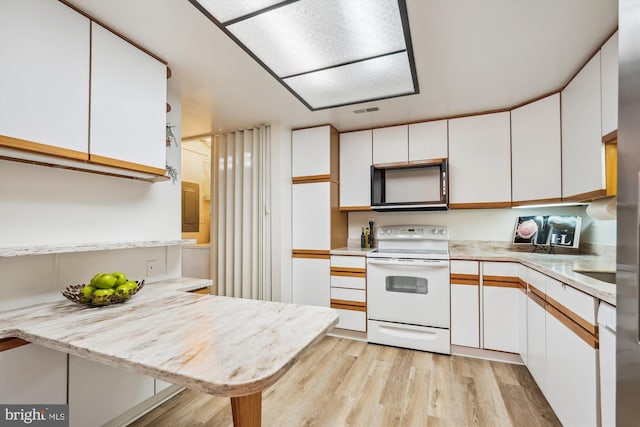 kitchen featuring light countertops, light wood finished floors, white range with electric stovetop, and white cabinets