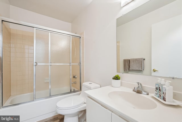 full bathroom featuring bath / shower combo with glass door, vanity, and toilet