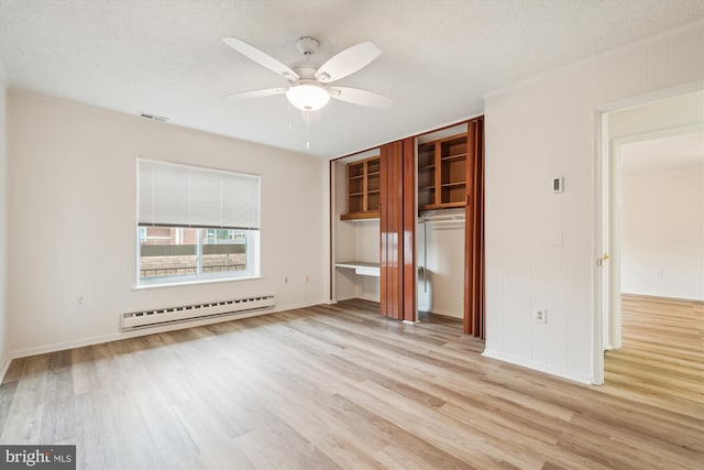 unfurnished bedroom with light wood finished floors, visible vents, a baseboard heating unit, a ceiling fan, and a textured ceiling